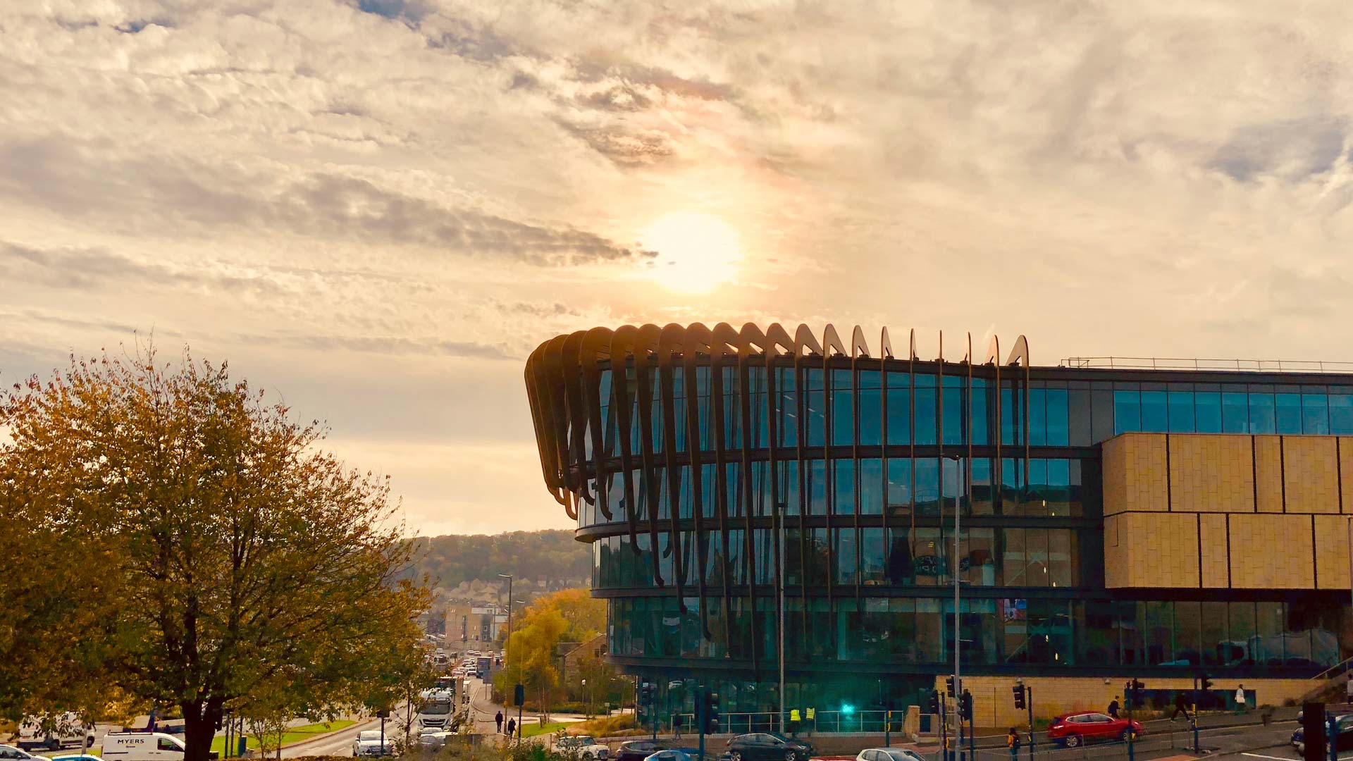Picture of the Oastler building with a low autumn sun behind it.