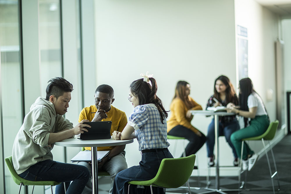 Students sat around a table in Oastler Building