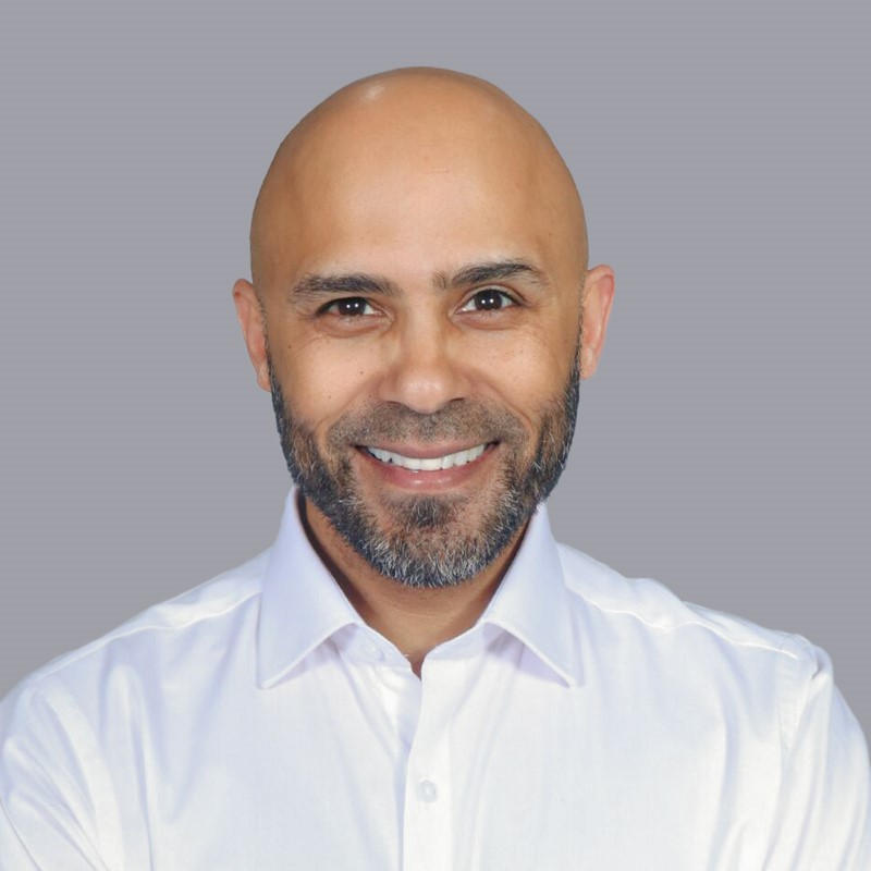 Headshot of Professor Ali Khan smiling at the camera