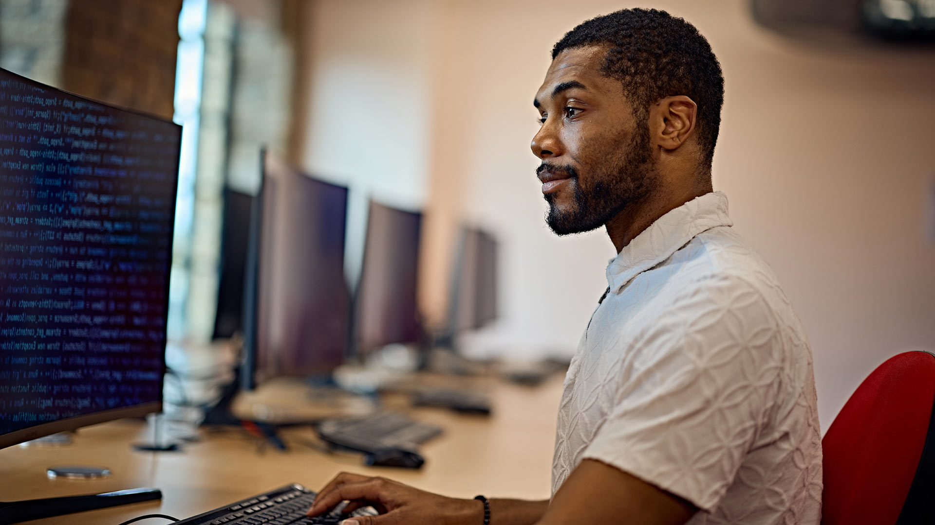 A student looking at code on a computer monitor.