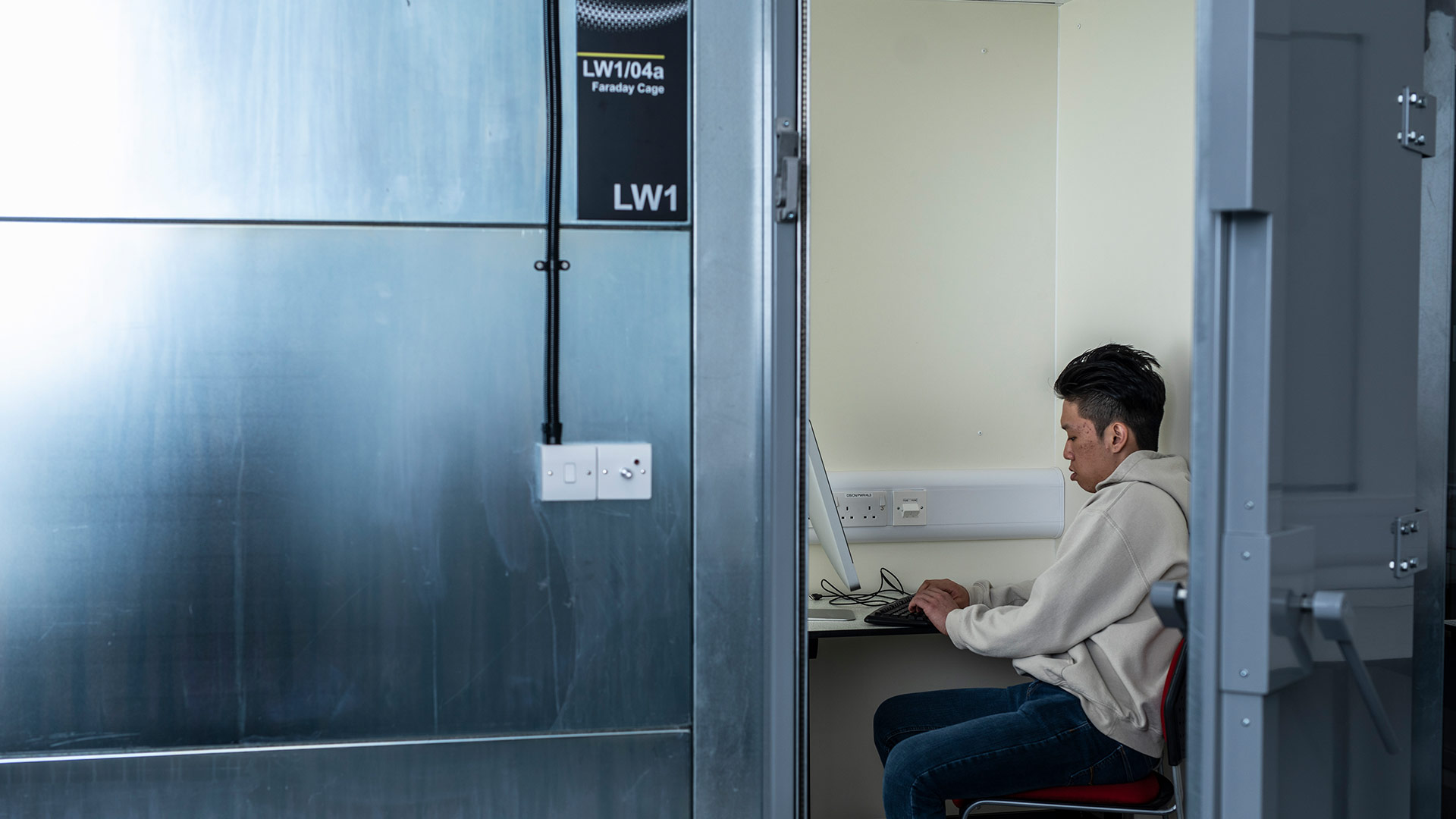 A student sat working, inside the University of Huddersfield's Faraday Cage Cyber Security facility.