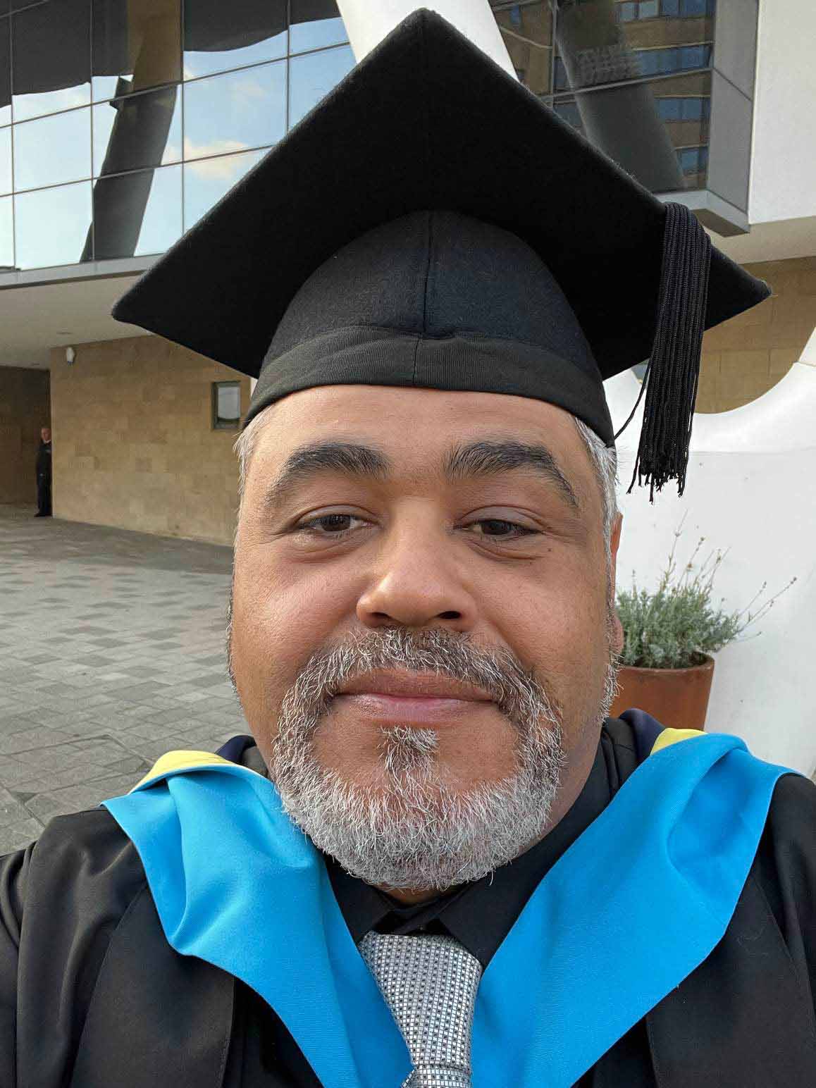 Amro Elrouby smiling while wearing a graduation hat