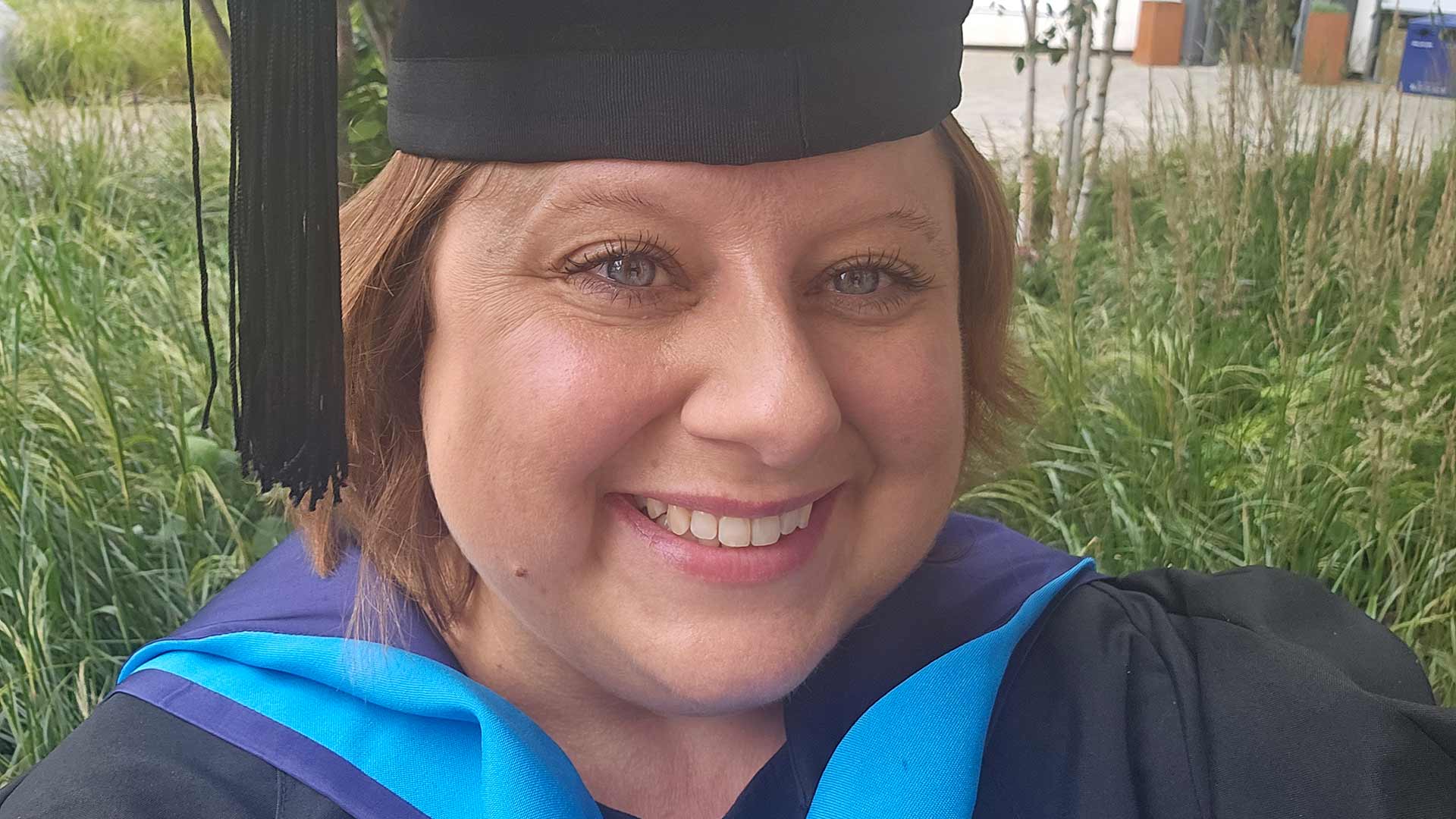 Headshot of Caroline in graduation gown and cap.