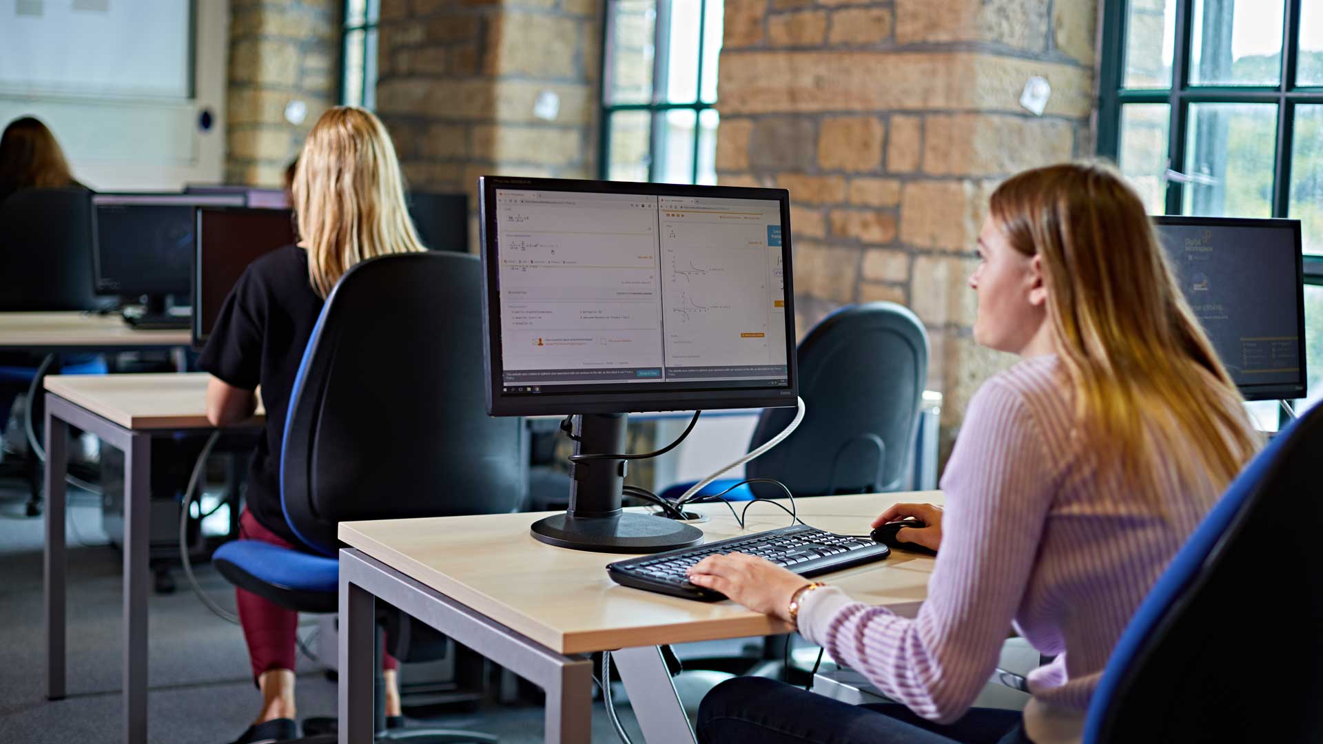 A student sits down at a computer in the Maths lab