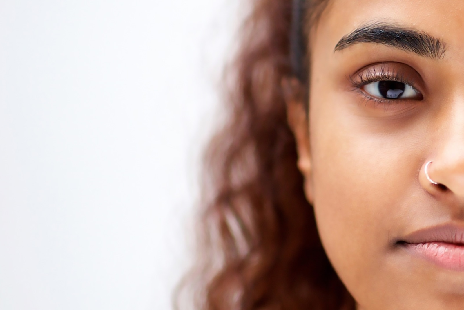 Young woman's face to the right hand side of the frame, she is unsmiling