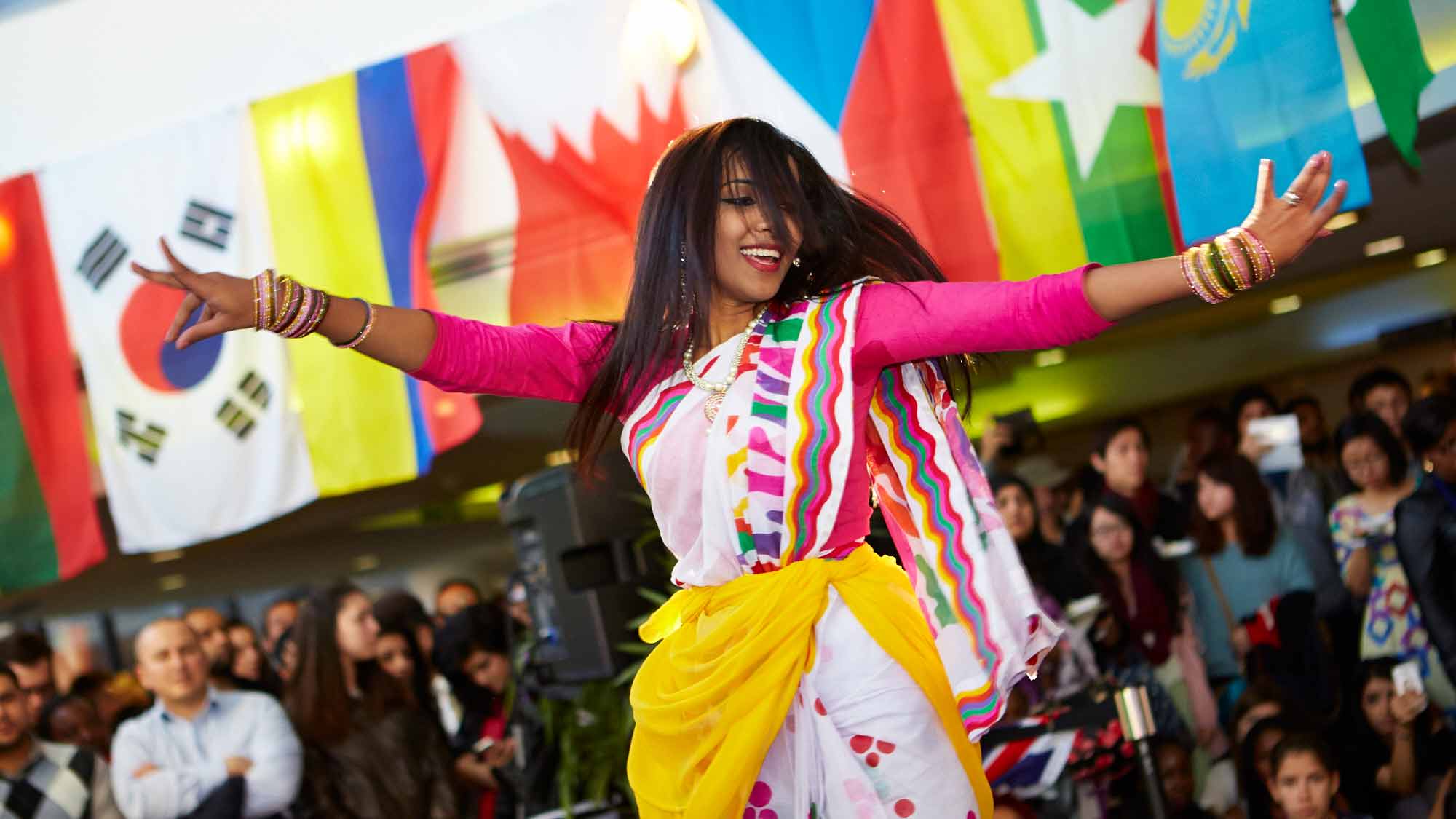 Women dancing in traditional clothing at a society event