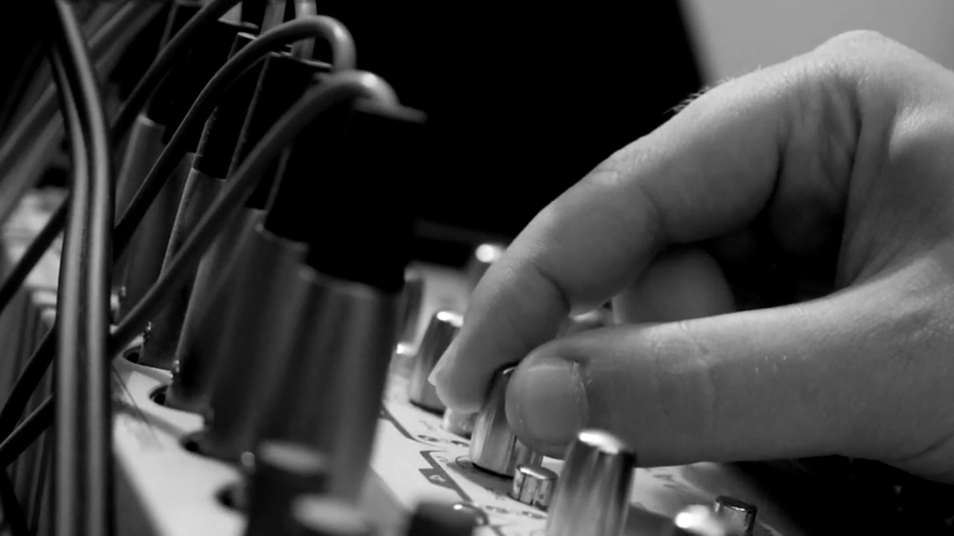 hand turning knobs on a mixing desk