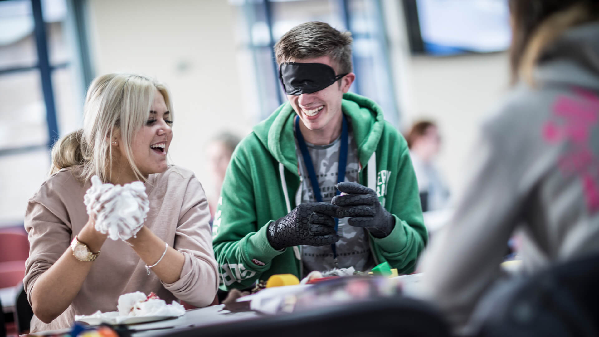 Two students smiling whilst completing an activity at a taster day