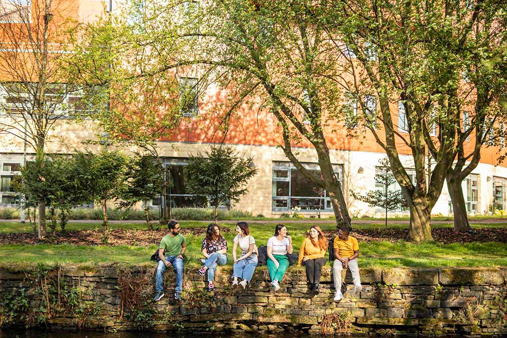 Students on a wall on campus