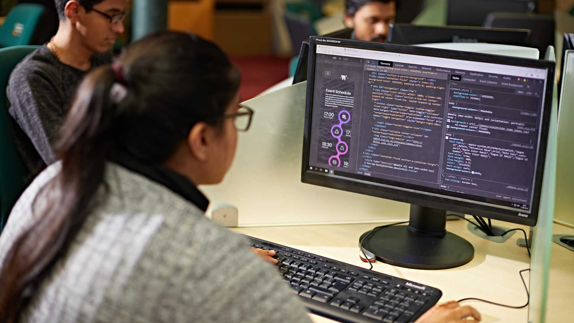 A student is programming while sat at a computer.