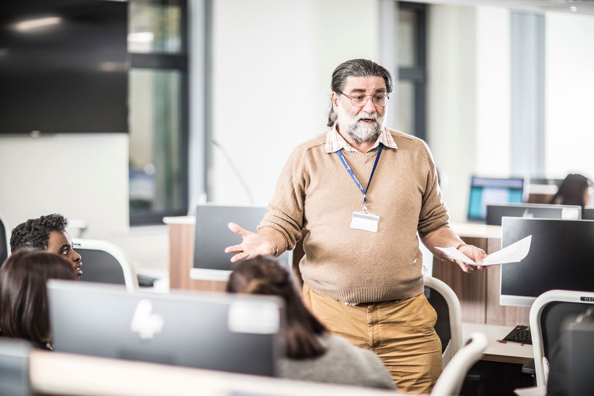 A teacher in a computer lab with students in class